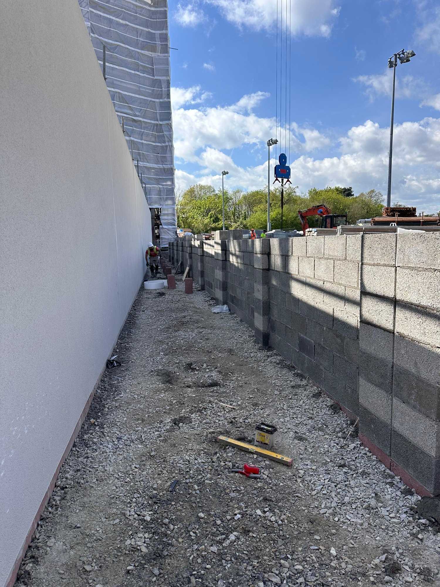 Lungo muro in blocchi, a squadra e a piombo